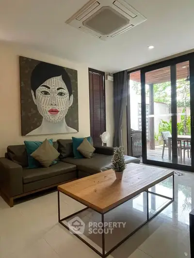 Stylish living room with modern art and large glass doors opening to a patio.