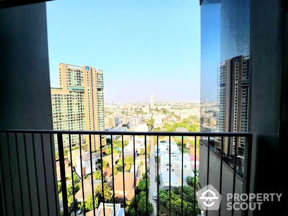 Stunning cityscape view from a high-rise balcony with modern buildings and clear skies.