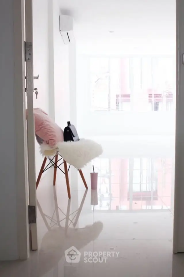 Bright minimalist room with glossy floors and stylish chair, perfect for modern living.