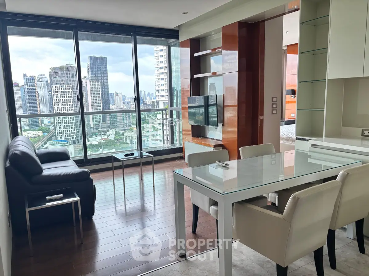 Modern living room with stunning city view, sleek furniture, and floor-to-ceiling windows in a high-rise apartment.