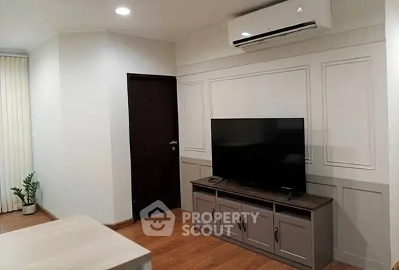 Modern living room with sleek TV setup and air conditioning unit
