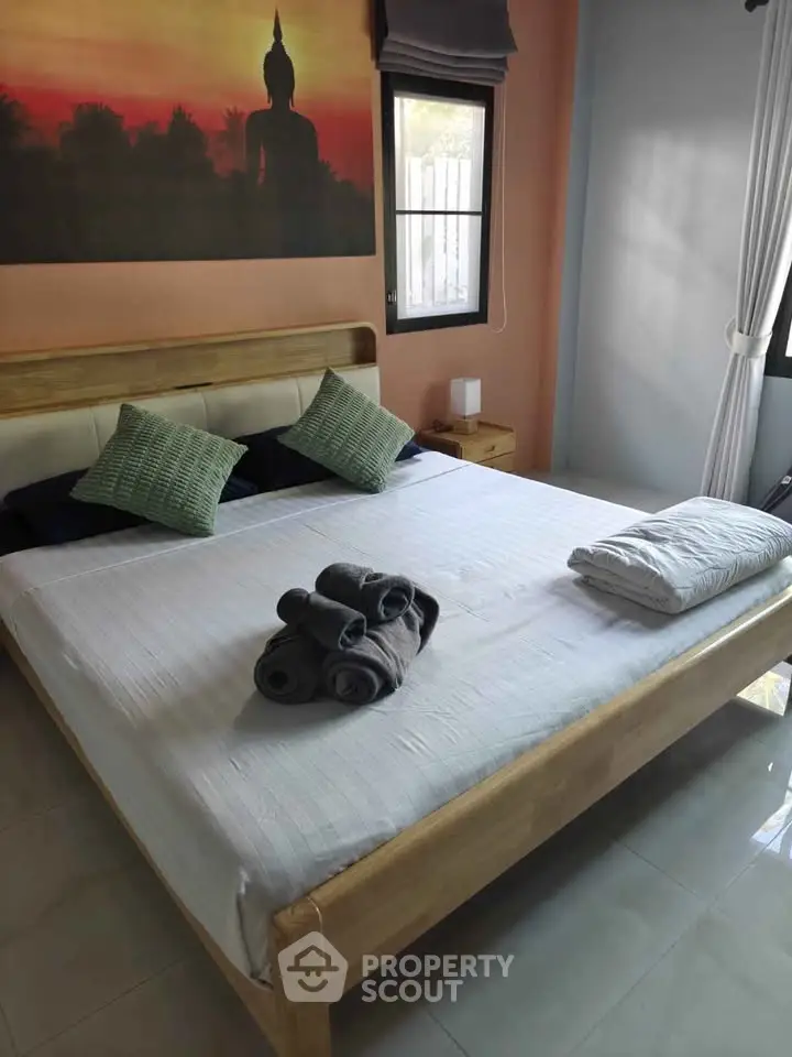 Cozy bedroom with a large bed, stylish decor, and natural light from windows.