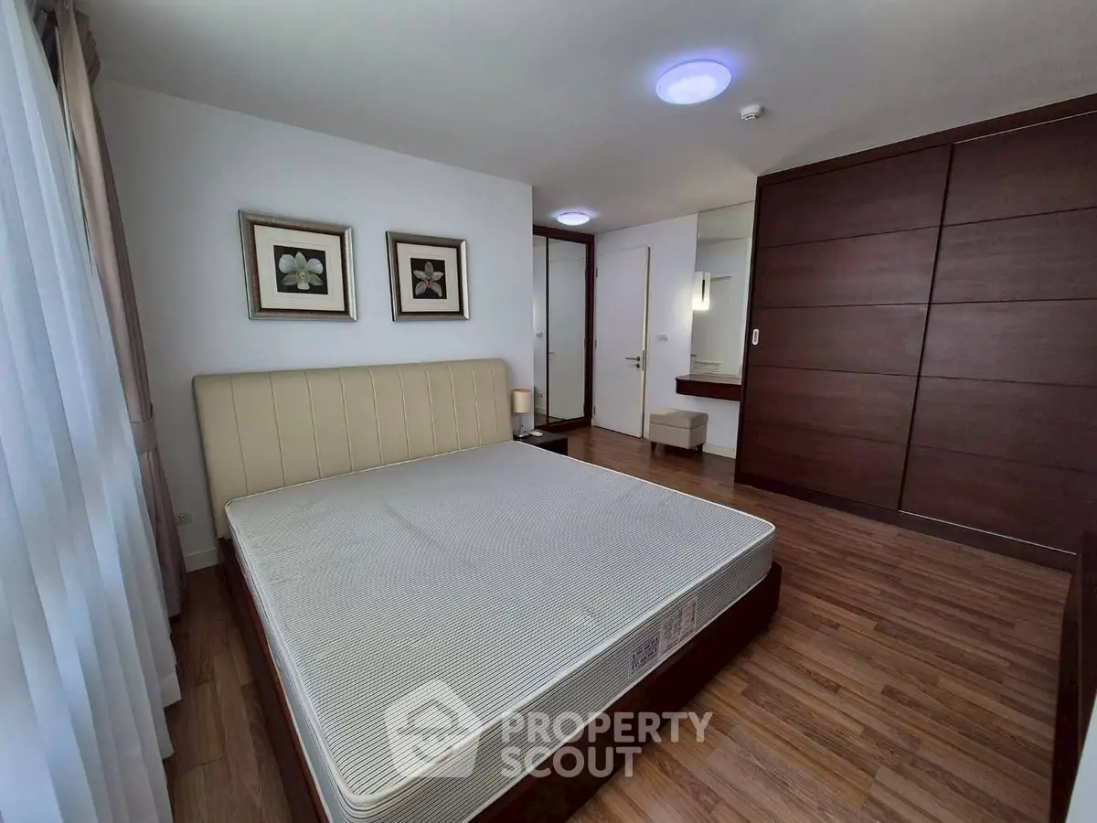 Spacious bedroom with modern decor and wooden flooring