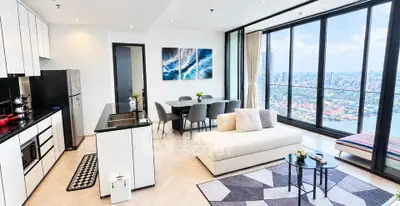 Luxurious open-plan living room with stunning city view and modern kitchen.