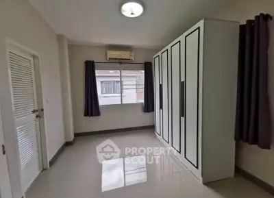 Spacious bedroom with large wardrobe and window view