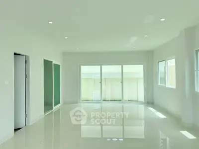 Spacious modern living room with large windows and glossy white flooring