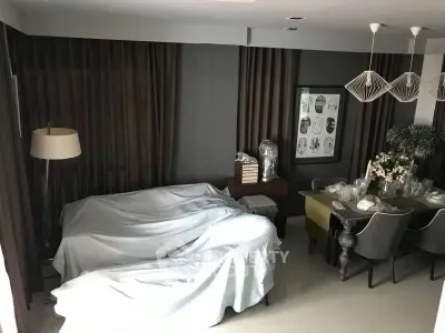 Stylish living room with modern decor and elegant dining area, featuring contemporary lighting and cozy ambiance.