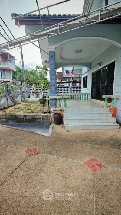 Charming suburban home with spacious front yard and inviting entrance steps, perfect for family living.