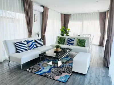 Modern living room with stylish decor, large windows, and elegant furniture.