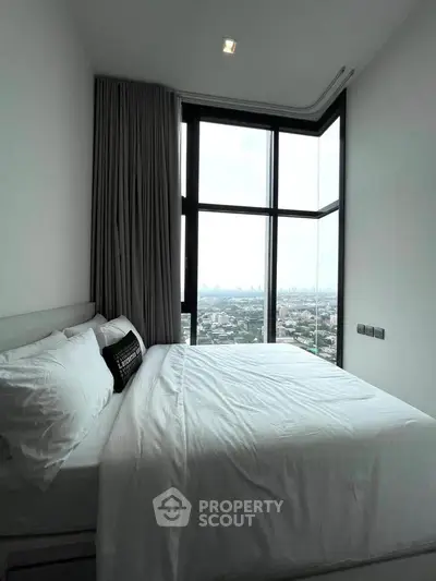 Luxurious bedroom with panoramic city view and modern design in high-rise apartment.