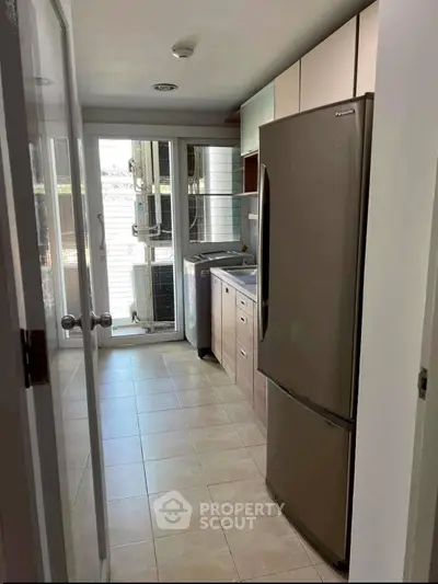 Modern kitchen with sleek appliances and ample natural light