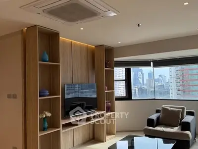 Modern living room with city view, stylish furniture, and built-in wooden shelves.