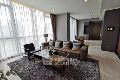 Spacious modern living room with large windows and elegant decor in a high-rise apartment.
