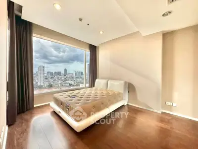 Spacious bedroom with city view and modern design in high-rise apartment