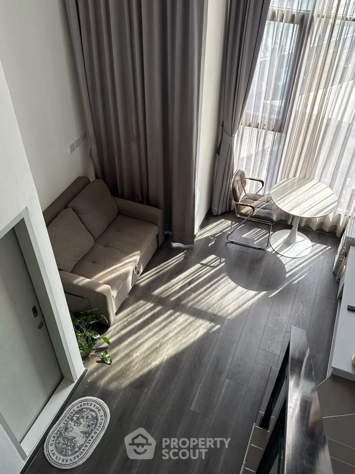 Modern living room with high ceilings, large windows, and stylish furniture.