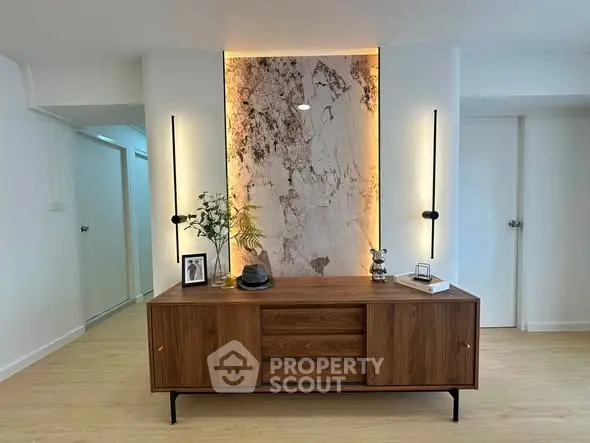 Stylish modern interior with elegant wooden console and artistic wall feature in a bright room.