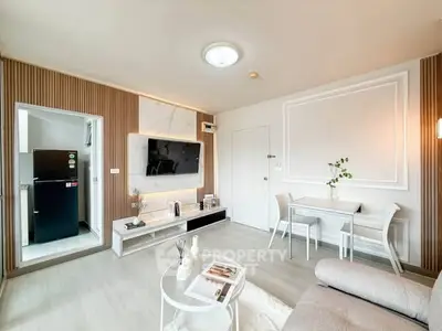 Modern living room with stylish decor and open layout, featuring a cozy dining area and sleek TV setup.