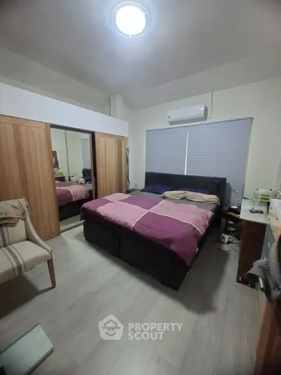 Cozy bedroom with modern furnishings and ample storage space, featuring a comfortable bed and stylish decor.