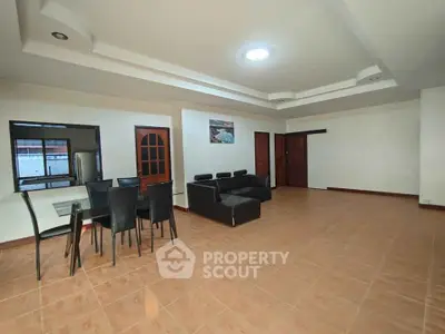 Spacious living room with modern furniture and dining area, perfect for family gatherings.