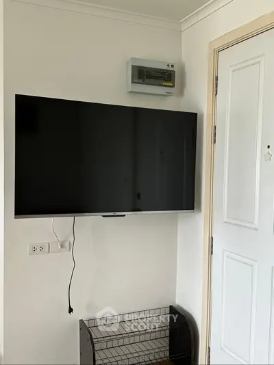 Modern apartment interior with wall-mounted TV and sleek door design
