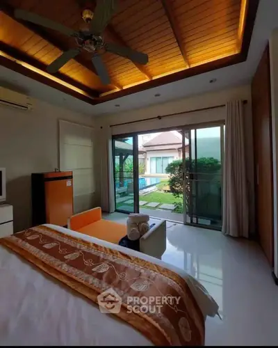 Luxurious bedroom with pool view and elegant ceiling design in modern home.