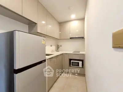 Modern kitchen with sleek cabinets and built-in appliances in a compact layout.