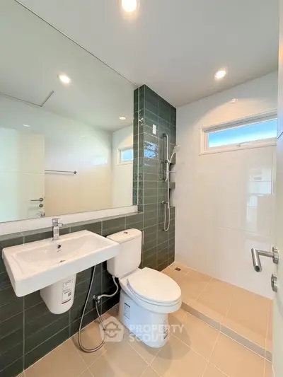 Modern bathroom with sleek fixtures and stylish green tile accents