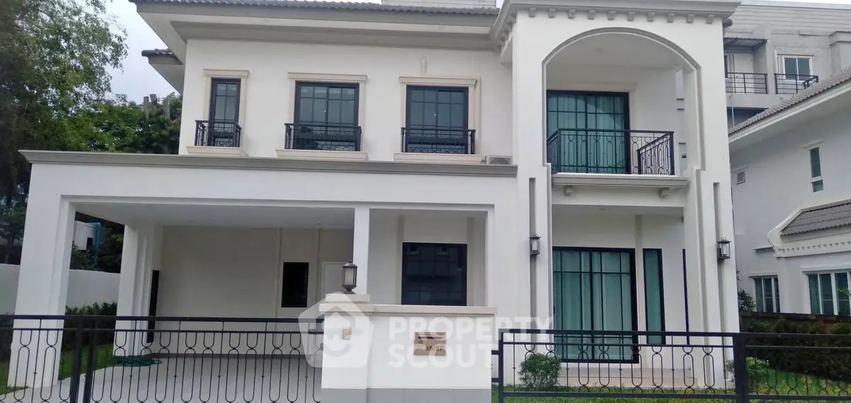 Elegant two-story white house with modern design and spacious driveway.