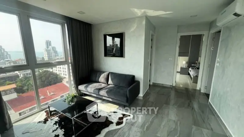 Modern living room with city view, sleek furniture, and natural light.