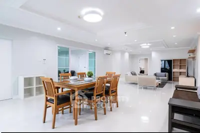 Spacious modern living and dining area with elegant furniture and bright lighting.