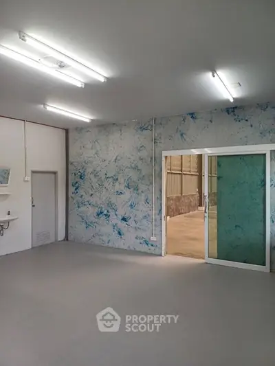 Spacious industrial unit with unique blue accent wall and sliding glass door