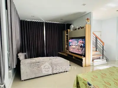 Spacious living room with modern sectional sofa and large TV, perfect for entertainment.
