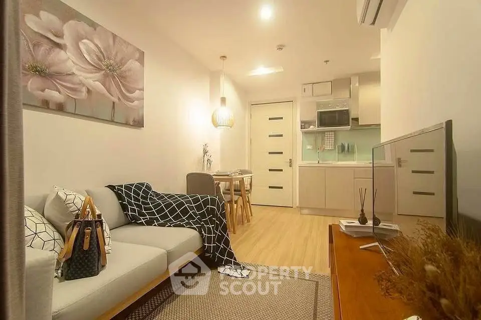 Modern living room with cozy decor and open kitchen layout in stylish apartment.