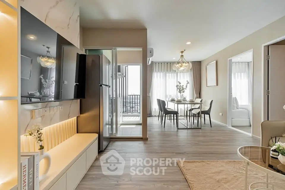 Modern open-plan living room with dining area and balcony access, featuring elegant decor and natural light.