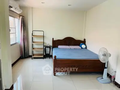 Spacious bedroom with elegant wooden bed and natural light