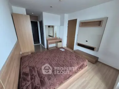 Modern bedroom with wooden furniture and cozy brown bedding in a stylish apartment.