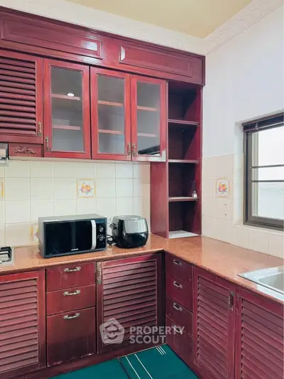 Charming kitchen with rich wooden cabinets and modern appliances, perfect for culinary enthusiasts.