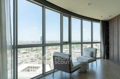 Stunning high-rise apartment with panoramic city views and elegant seating area.