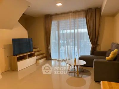 Spacious living room with modern decor and large windows offering natural light.