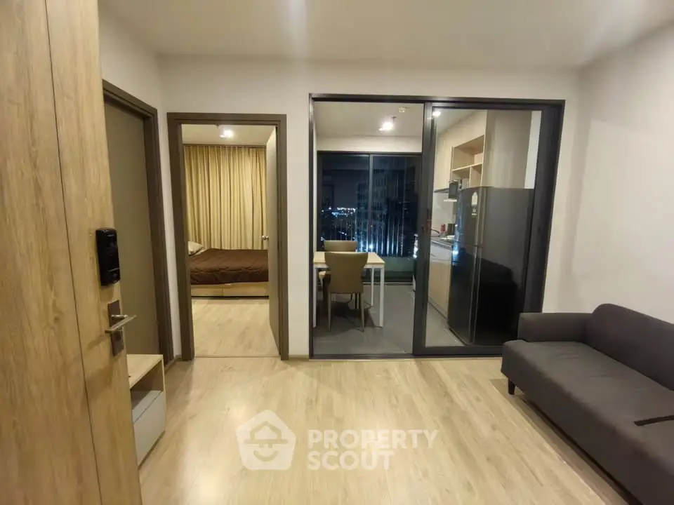 Modern apartment interior with open layout, featuring a cozy living room, dining area, and bedroom view.