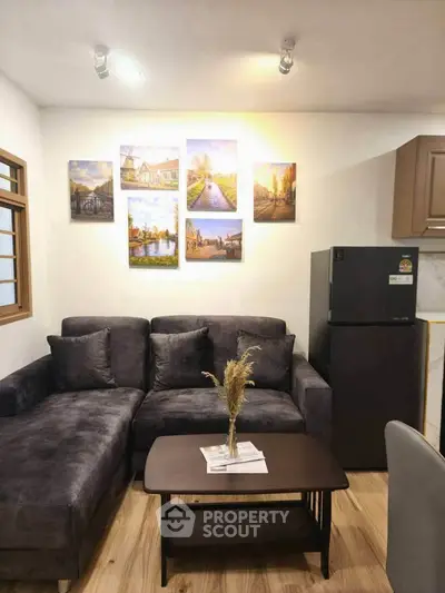 Cozy living room with modern sofa, stylish decor, and sleek refrigerator, perfect for urban living.