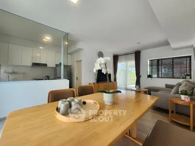 Spacious open-plan living room with modern kitchen and elegant dining area, perfect for family gatherings.