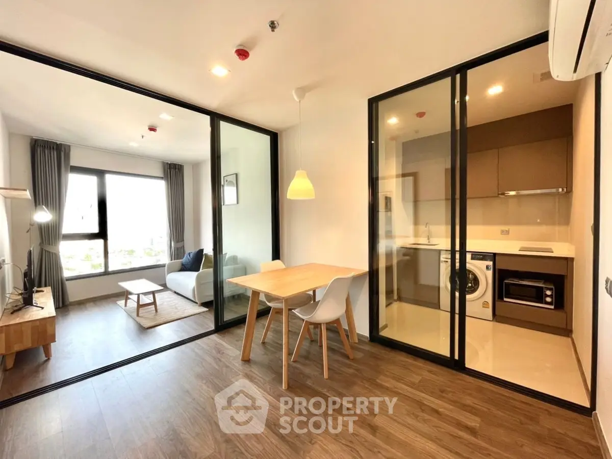 Modern open-layout apartment with glass partition, featuring cozy living area and stylish kitchen.