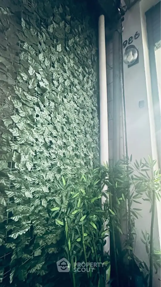 Charming exterior with lush greenery and modern facade, perfect for urban living.