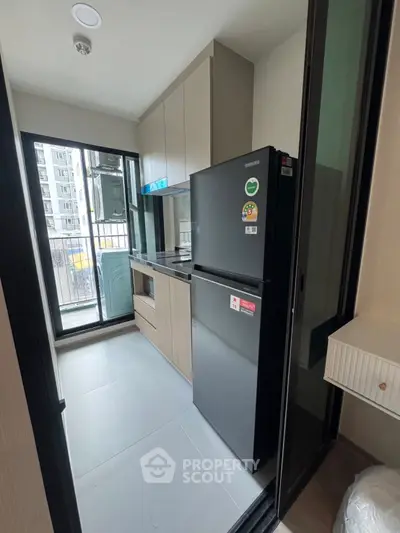 Modern compact kitchen with sleek appliances and balcony view