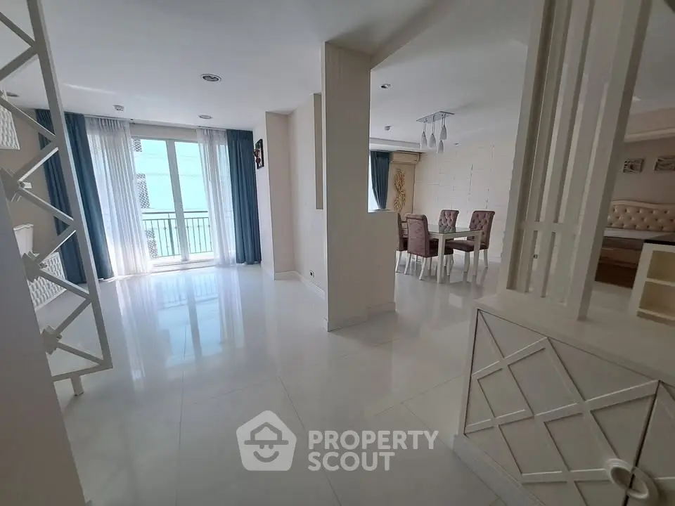 Spacious modern living room with dining area and large windows in a stylish apartment.