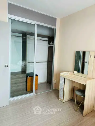 Modern bedroom with sliding closet and stylish vanity in a cozy apartment.