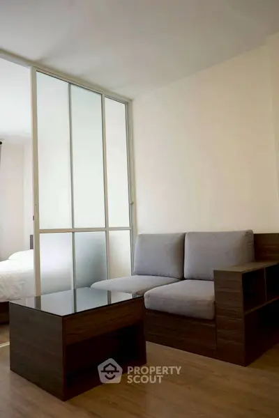 Modern living room with sleek furniture and sliding glass partition