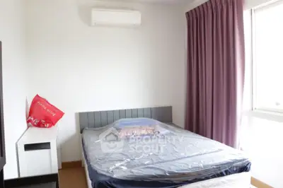 Cozy bedroom with air conditioning and natural light, ideal for relaxation.