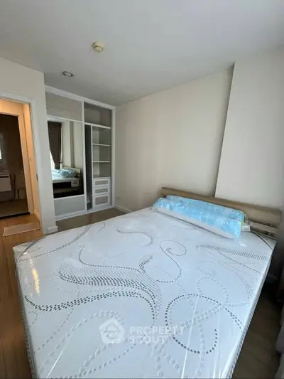 Spacious bedroom with modern design and ample natural light, featuring a comfortable bed and built-in wardrobe.